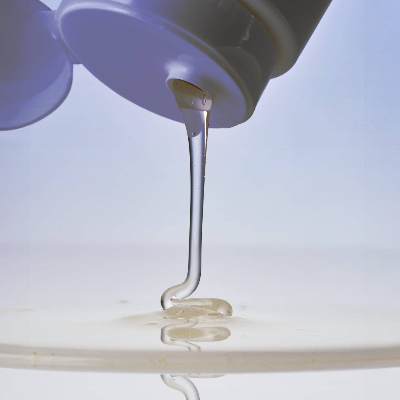 Voduz 'Cleanse It' Shampoo Bottle pouring shampoo onto a glass surface against a white background.