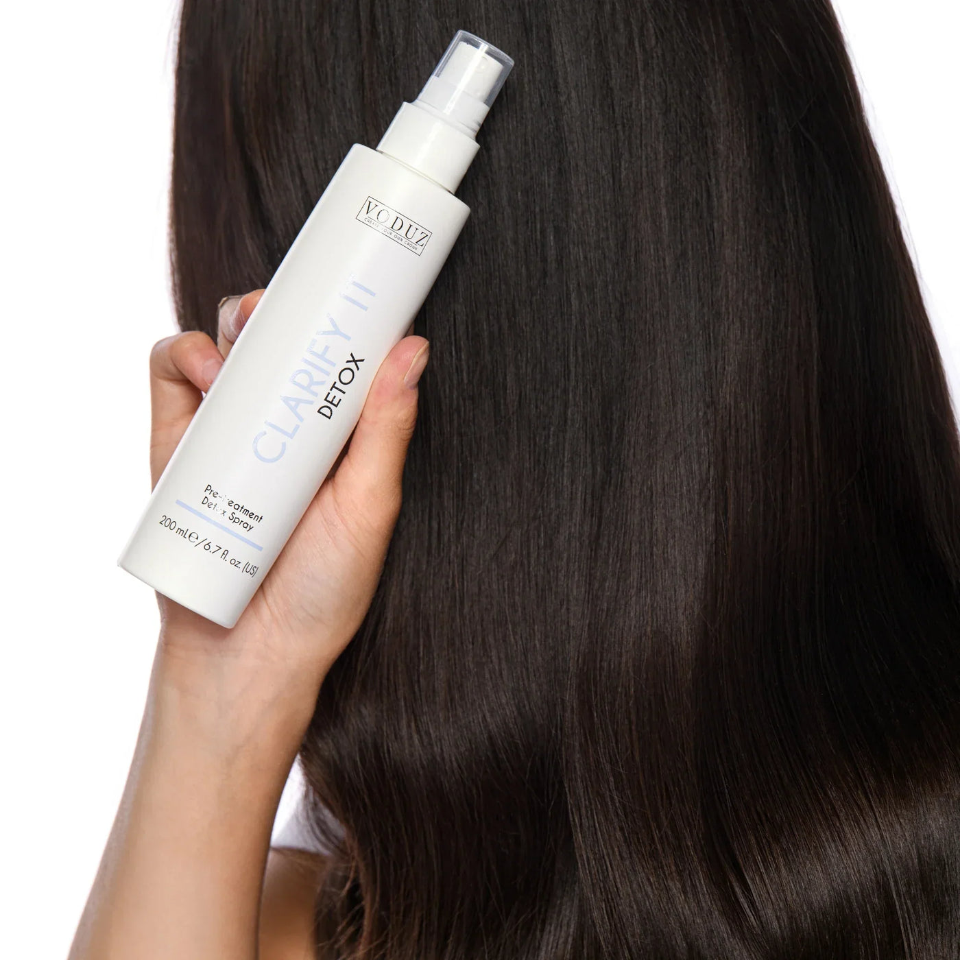 Model with perfectly clean, shiny detoxed hair - holding a bottle of 'Clarify It' Detox Pre Treatment Spray (200ml) against her locks