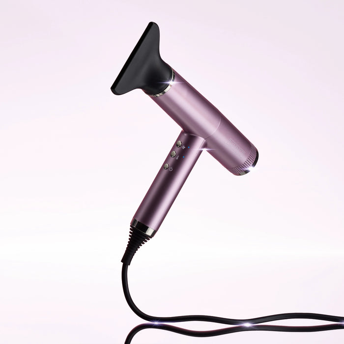 A metallic purple VODUZ 'Blow Out' - Pro Hair Dryer with a black nozzle attachment and black power cord, shown on a clean white background with a soft reflection.