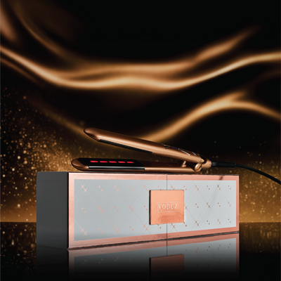 Voduz ‘Legacy’ Infrared Straightener - Bronze hair straightener on a decorative stand with a dark, swirling gold background