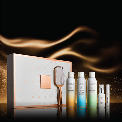Voduz Ultimate Vault hair care set of skincare products and a paddle brush with a decorative box on a dark background